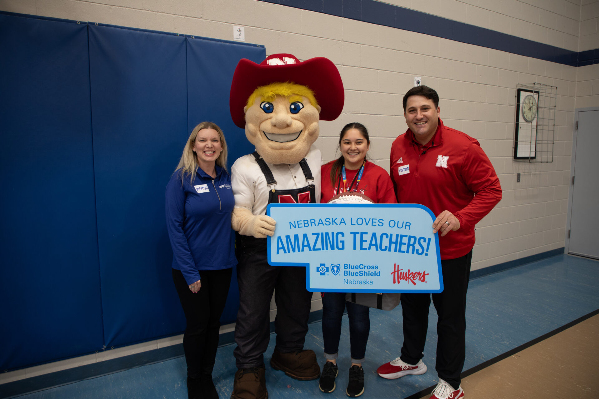 Outstanding Nebraska Teacher Award recipient poses with Herbie Husker and representatives from BCBSNE and Husker Athletics